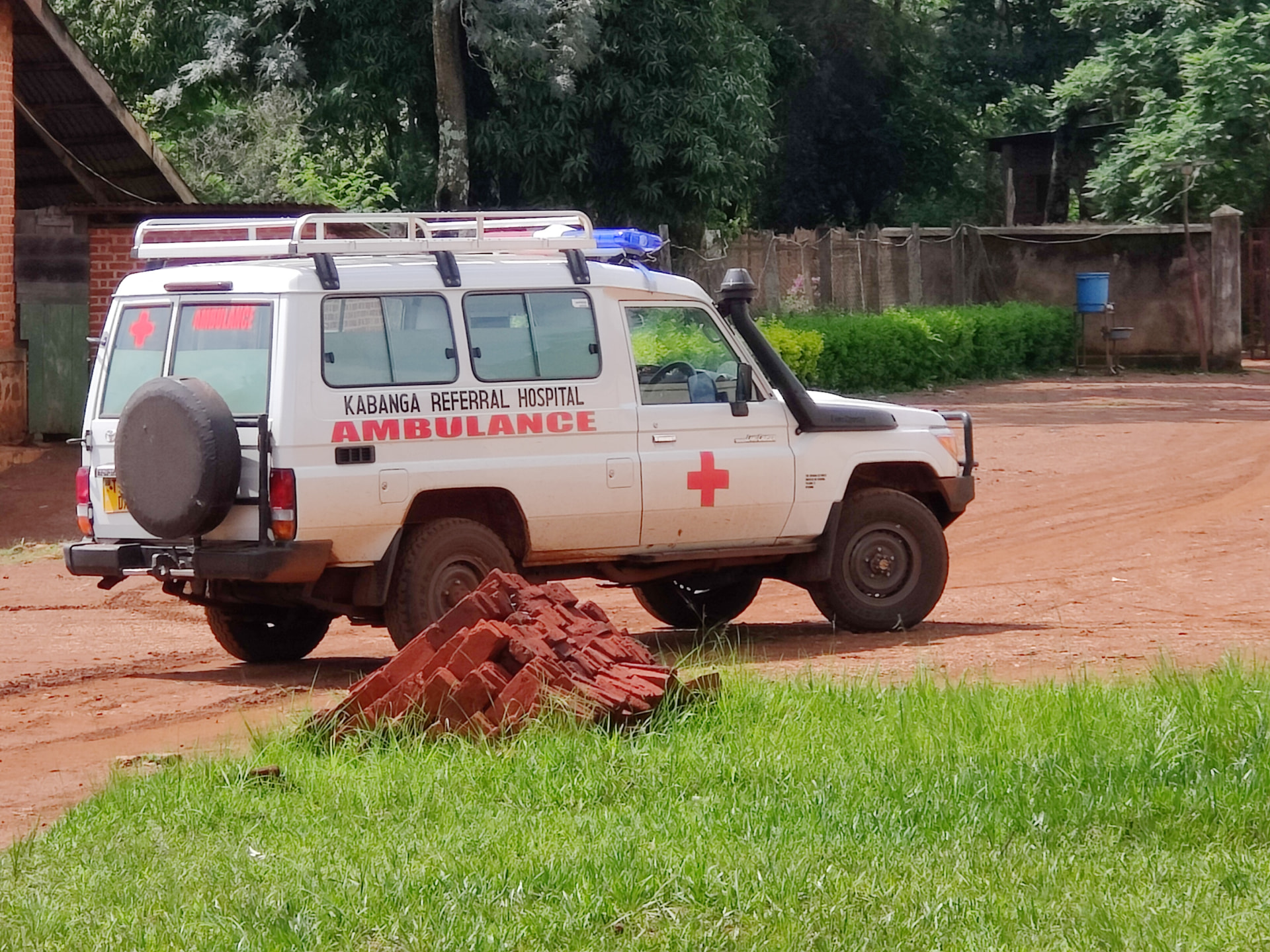 Ambulance van Kabanga Referral Hospital op een onverharde weg in Tanzania