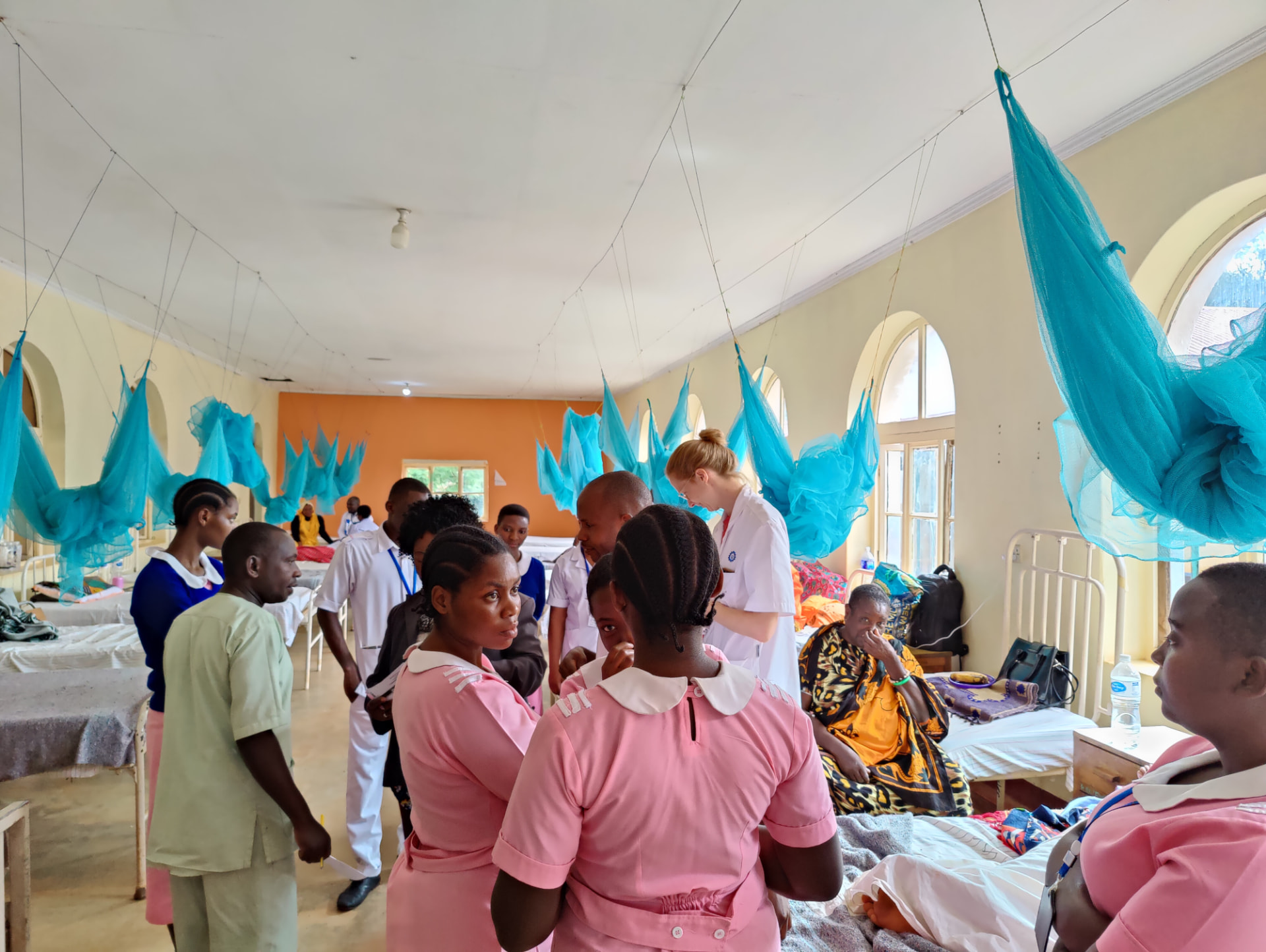 Medisch team in een ziekenhuiszaal in Tanzania met klamboe's boven de bedden